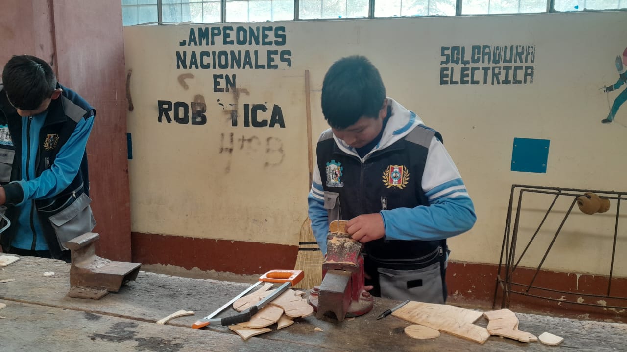 Estudiante trabajando piezas de madera en taller