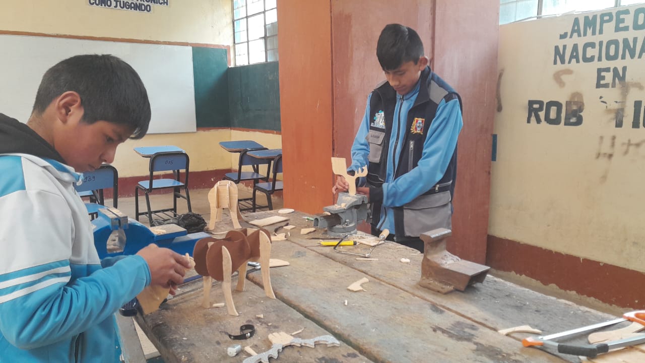 Estudiantes elaborando piezas de madera en taller t&eacute;cnico